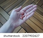 Small photo of three red pills in hand - morbidity and epidemics - vitamins