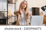 Small photo of Dislike. Upset businesswoman girl working on laptop computer at home office thumbs down sign gesture, expressing discontent, disapproval, dissatisfied bad work. Displeased serious freelancer woman