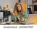 Small photo of Caucasian young woman freelancer crying counting cash insufficient amount of money. Financial crisis. Bankruptcy. Poverty and destitution. Female girl businesswoman with laptop sitting at home office