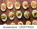 Small photo of Deviled eggs. Classic American appetizer favorite. Hard boiled eggs, cut in half and white pipped with yolk mixture. Garnished with scallions, salt and pepper. Easter dinner staple.