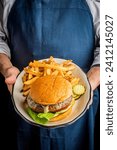Small photo of Hamburger. Bacon Cheeseburger. Classic traditional American bar, restaurant entree. Beef hamburger with Swiss and cheddar cheeses served with lettuce, tomato, onion and hand cut french fries.