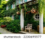 romantic house overgrown with ivy and flowers in the botanical garden on a sunny summer day in Augsburg, Bavaria, Germany                               