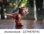 Small photo of A brown trex dinosaur figure for children