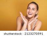 Small photo of Young girl smiling with sympathetic hand gesture. Isolated on yellow background