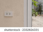 Small photo of White plug on white wall with a garden in the background, plug socket, electric, plug outlet, plug background. White outlet interior, interior electric outlet in home.