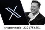 Small photo of Jakarta - November 23,2023: Twitter new logo known as X seen on smartphone with Elon musk photo on blurred background