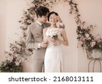 Small photo of Hanoi city, Vietnam - April 2021: The bride and groom stand side by side intimately, affectionately. Happy couple in love. Korean-style wedding photography. Happy concept.