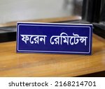 Small photo of Sylhet, Bangladesh- June 04, 2022: This is the Office Table Desk Name plate.Bengali Written that is english meaning Foreign Remittance.