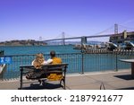Sightseeing at Oakland Bay Bridge, Yerba Buena island. This is iconic view from the Pier at the downtown San Francisco, California. There is ferry boat transporting tourist and passengers to both side