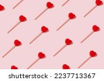 Red heart shaped lollipops pattern on pastel background. Minimal Valentine or love concept.