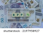 Small photo of Word RPP with blocks standing on money, "RPP" is a shortcut for The Monetary Policy Council. % sign as a concept for increased interest rates.