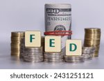 Small photo of FED inscription on plastic blocks. FED is the abbreviation for the U.S. central banking system—the Federal Reserve, hundred dollar banknotes on the background.