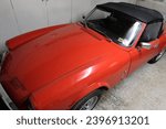 Small photo of Somerset, England - 08252017: Exterior view of classic Triumph Spitfire 1500 car in bright red with convertible roof
