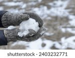Small photo of Woman in Winter gloves making snowball. Playing active games in winter. Hands in knitted mittens holding snowball. Wintertime leisure cold weather.