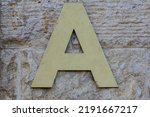 Close-up of the plastic letter A hanging on the building to inform residents about the entrance number. Letters denoting parts of a residential building.