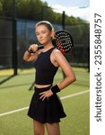 Small photo of Padel tennis player with racket. Girl athlete with paddle racket on court outdoors. Sport concept. Download a high quality photo for the design of a sports app or web site.