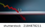 Recession, Inflation and Depression Concepts. Economic Crisis. Graph Fall Down, Business Collapse. Two Miniature Figure of Businessman Looking at a Red Graph Arrow Down