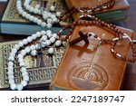 Small photo of Religious symbols : Muslim Prayer Beads and Quran, Christan Rosary and Bible. Interreligious or interfaith dialogue concept.