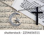 Small photo of Religious symbols : Muslim Crescent and Star with Quran, and Christan Cross with Bible. Interreligious or interfaith dialogue concept. 01-16-2022