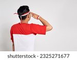 Back view young Asian man standing confidently giving a salute and respectful gestures isolated over white background. Celebrate Indonesia independence day on 17 August