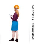 Small photo of Backview of business woman in construction helmet stands and enjoys tablet or using mobile phone. Isolated over white background. Young woman engineer working on tablet. Engineer scorekeeper at work