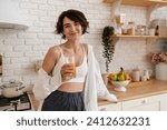 young pretty woman cooking at home, morning kitchen, healthy food, drinking orange juice