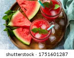 Cold Watermelon Smoothie. Summer Watermelon drink and slices of watermelon on a light stone table.