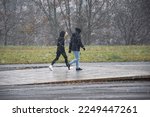 couple of people walking surprised by a sudden snowfall