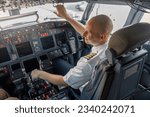 High angle view of professional pilot sitting in an airplane cabin, ready for takeoff. Aircraft, aircrew, occupation concept