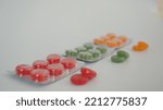 Small photo of Fruity and green colored throat lozenges in a pack, yellow and red lozenges in the background
