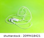 white headset or handsfree or earphones photographed on a green background
