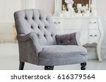 beige color upholstered chair in living room with flowers