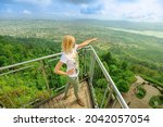 Woman by Zurich cityscape on a Swiss lookout tower on Uetliberg mountain in Swiss plateau of Switzerland. Canton of Zurich. Carefree girl with open arms looking panorama of Zurich with lake at sunset.