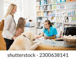 Small photo of Receptionist greeting dog in vet's surgery