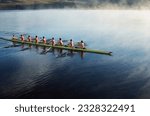 Rowing crew rowing scull on lake