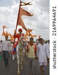 Small photo of Saswad road, Maharashtra, India-June 25 2014:The horseman in traditional attire bearing Dhwaja - a holy Fag, accompanied by devotees during annual Wari- pilgrimage from Alandi to Pandharpur.