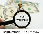 Small photo of Null Hypothesis.Magnifying glass showing the words.Background of banknotes and coins.basic concepts of finance.Business theme.Financial terms.