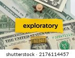 Small photo of exploratory.The word is written on a slip of paper,on colored background. professional terms of finance, business words, economic phrases. concept of economy.