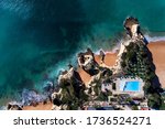 Aerial drone photo of the beautiful coastline near the Senhora da Rocha beach near Lagoa, in Algarve, with a swimming pool on the cliffs, in Portugal