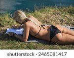A girl in a bikini sunbathes in ...