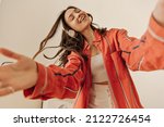 Bottom view of charming european cute lady in headphones with closed eyes on white background. Brown haired listens to new pop music, enjoying singing song while relaxing in cozy living room house.