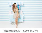 Happy summer time of pretty fashionable model in dress having fun on striped background. Sweet dessert truck, cakes, laughing, expressing true positive emotions. Place for text