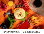 Small photo of Tongue Twister Beef Naga burger with fries and tomato slice isolated on wooden board side view of american street food