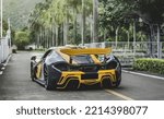 Small photo of Zhuhai, China- October 8,2022: A black and yellow McLaren P1 hypercar is parked on road