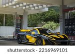 Small photo of Zhuhai, China- October 8,2022: A black and yellow McLaren P1 hypercar is parked in gas station