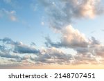 Sunset on blue sky. Blue sky with some clouds. blue sky clouds, summer skies, cloudy blue sky background. Aerial sunset view.  Evening skies with dramatic clouds. View over the clouds.
