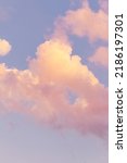 Small photo of Vertical shoot.Light pink clouds in sunset blue sky. Pastel colors of clouds, sunrise sundown natural background.Pink purple clouds in blue sky while sunset twilight magic happening in nature, defocus