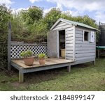 Small photo of Old Grey Kids Cubby house with deck in backyard