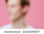 Small photo of strongly blurred beyond recognition portrait of a man in light clothes