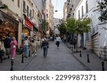 Small photo of People and shops on Galip Dede Street in Galata district. Istanbul, Turkey - May 3, 2023.